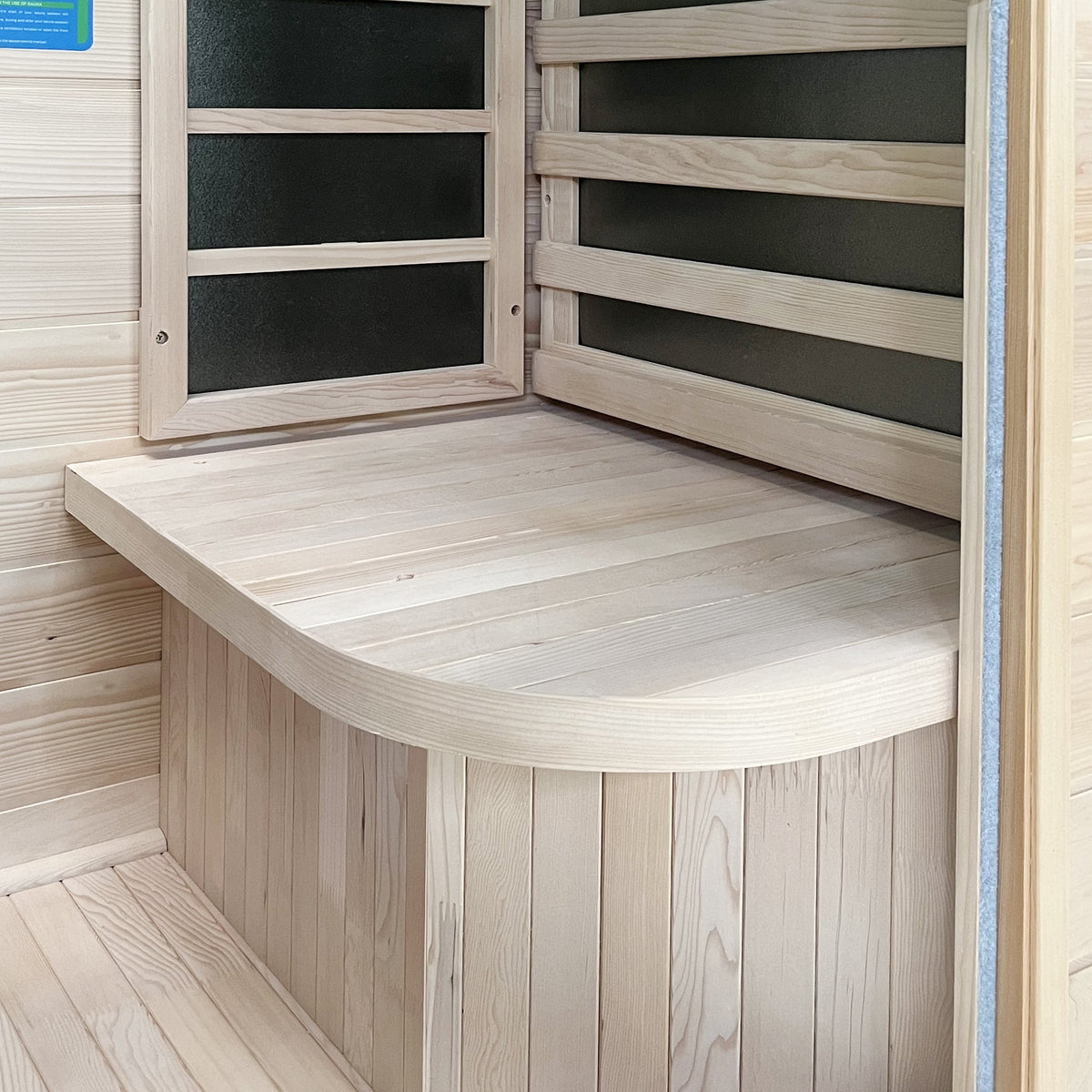 Inside the sauna: curved hemlock bench with carbon heater panels on the back and side walls